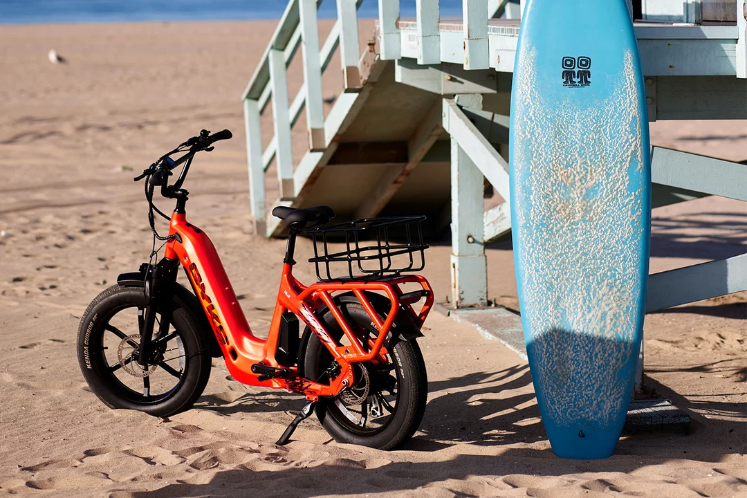 Collie Cargo burnt orange parked at the beach with a surfboard